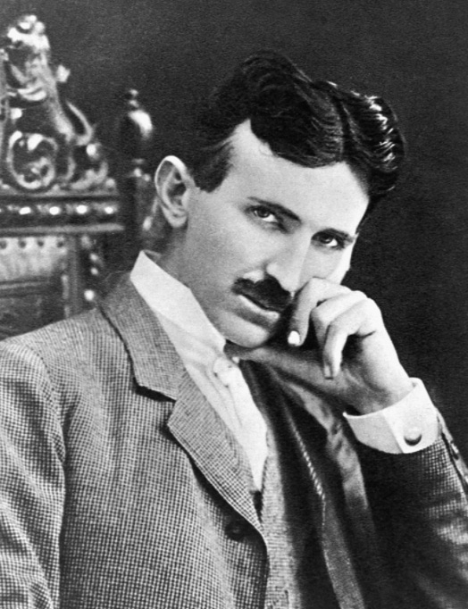Photograph of Nikola Tesla, a slender, moustachioed man with a thin face and pointed chin